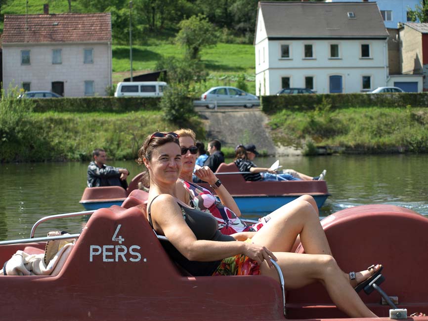 2 Treboote auf der Regnitz, auf dem vorderen sitzen entspannt zwei sommerlich gekleidete Frauen.