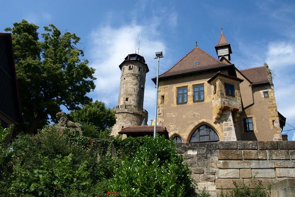 Mir wehrhaften Mauern und einem Turm mit Schiessscharten und Zinnen trohnt  die Altenburg über uns im blauen Himmel.