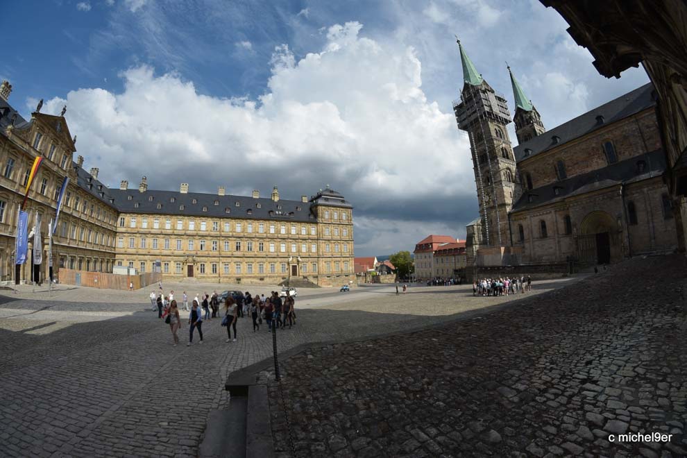 Der weite kopfsteingepflasterte Domplatz wird umfasst von der barocken neuen Residenz links und dem Dom auf der rechten.