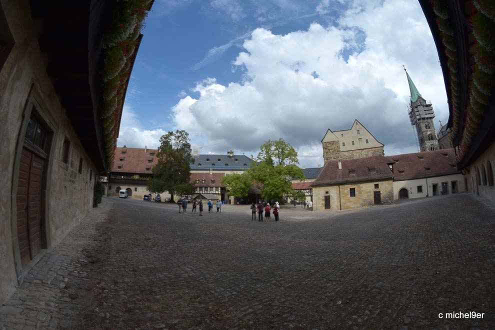Ein weiterer Platz gesäumt von einen rechteckigen Fachwerkgebäude der alten Hofhaltung. Darüber ragen die 4 Türme des Bamberger Doms.