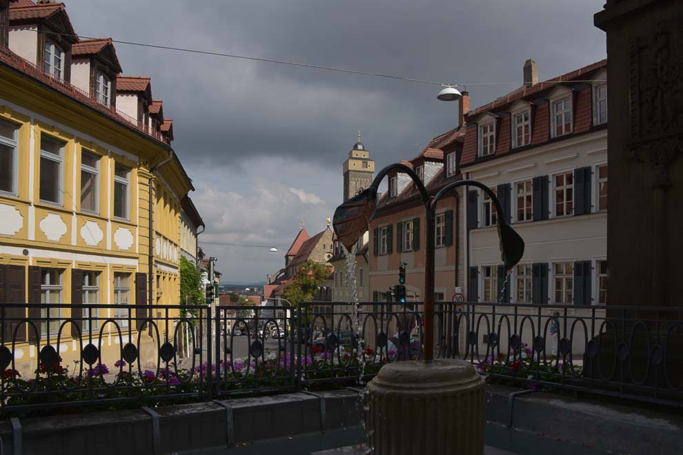Hinter einem dekorativen Brunnen führen links und rechts Häuserzeilen bergab den Kaulberg entlang bis zur oberen Pfarrkirche.